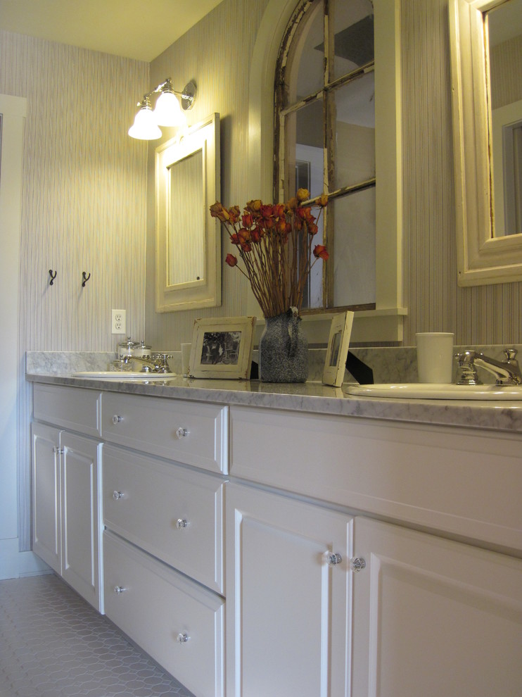 This is an example of a mid-sized traditional bathroom in DC Metro with a drop-in sink, raised-panel cabinets, white cabinets, marble benchtops, an alcove tub, an alcove shower, a two-piece toilet, white tile, porcelain tile, blue walls and porcelain floors.