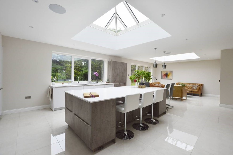 Large contemporary l-shaped open plan kitchen in Other with flat-panel cabinets, grey cabinets, metallic splashback, mirror splashback, stainless steel appliances, porcelain floors, multiple islands, white floor, white benchtop, an undermount sink, quartzite benchtops and coffered.