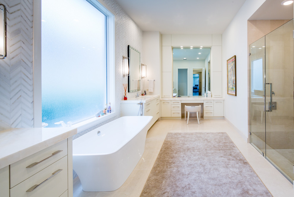 Inspiration for an expansive contemporary master bathroom in Miami with an undermount sink, flat-panel cabinets, white cabinets, onyx benchtops, a freestanding tub, a curbless shower, a one-piece toilet, white tile, stone tile, beige walls and limestone floors.