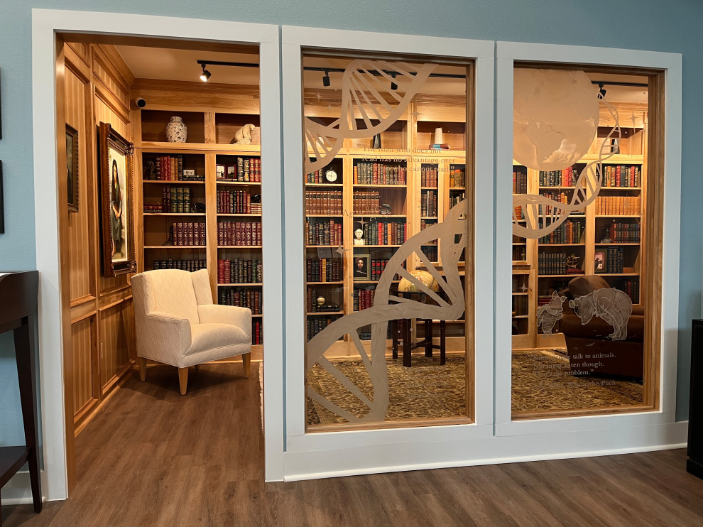 Foto di uno studio stile americano di medie dimensioni con libreria, pareti marroni, pavimento in legno massello medio, scrivania autoportante e pavimento marrone