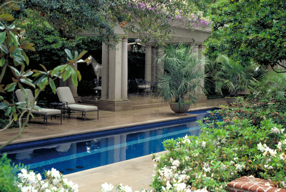 This is an example of a traditional backyard garden in Houston with natural stone pavers.