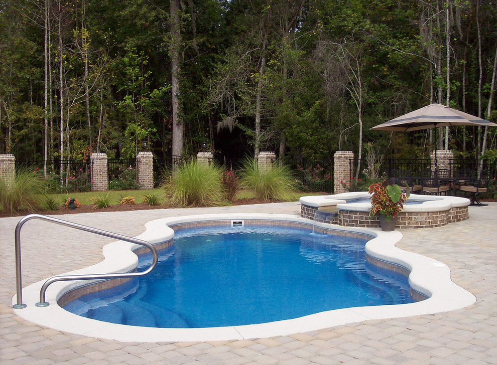 Mid-sized backyard brick and custom-shaped natural hot tub photo in Cincinnati