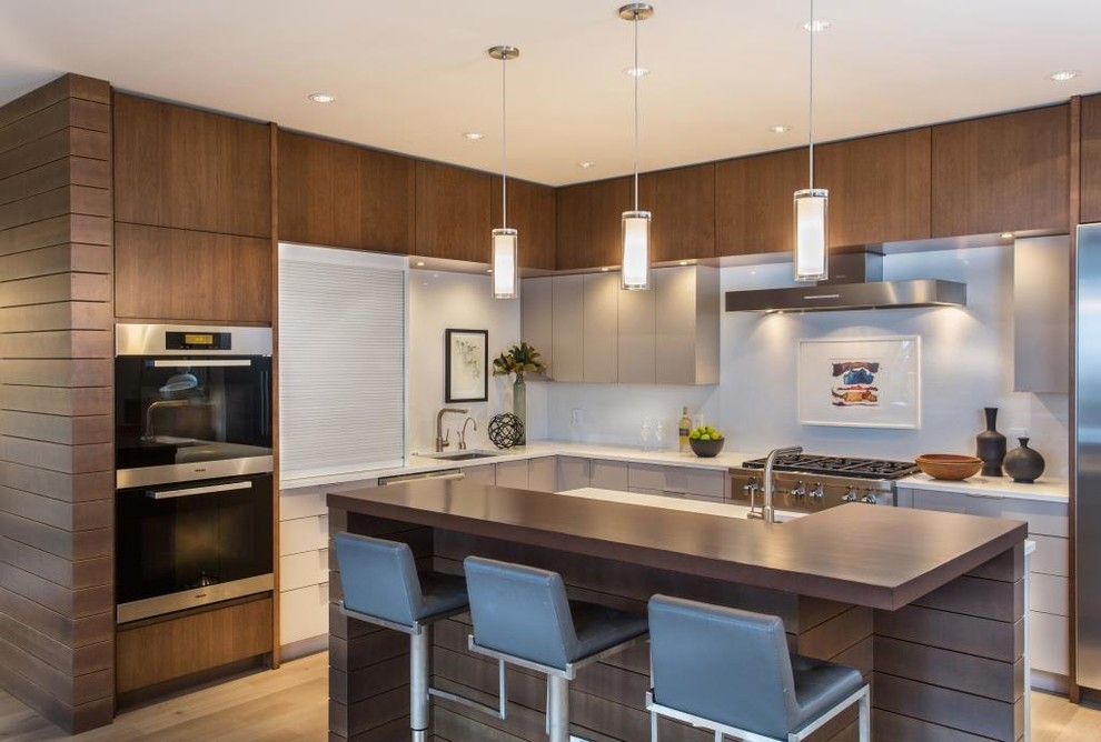 Inspiration for a contemporary eat-in kitchen in Seattle with a drop-in sink, flat-panel cabinets, grey cabinets, quartzite benchtops, white splashback, light hardwood floors and with island.