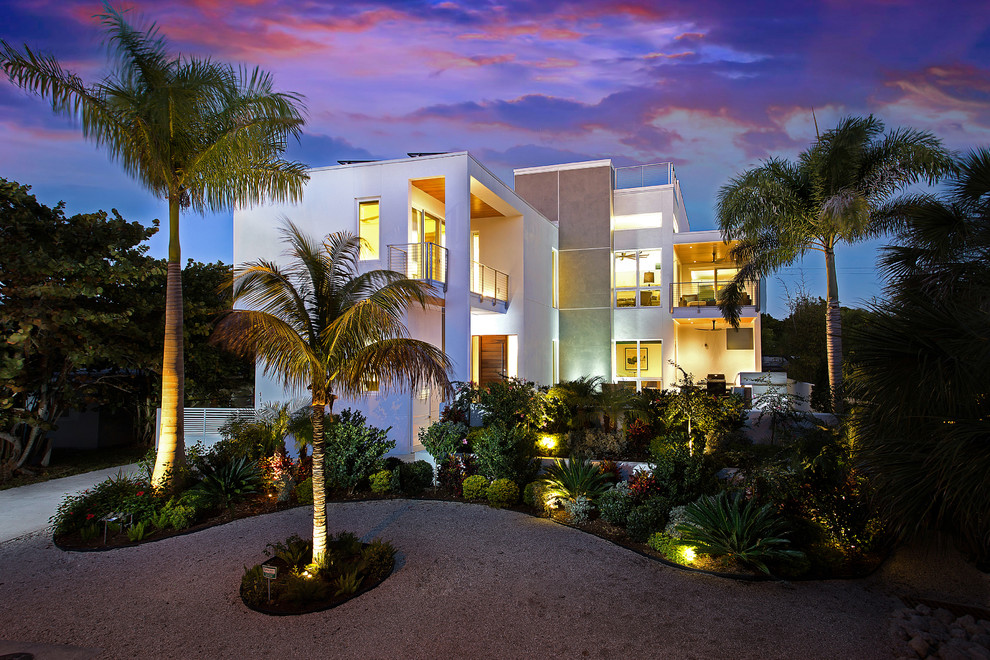 This is an example of a large modern two-storey stucco white house exterior in Tampa with a flat roof.