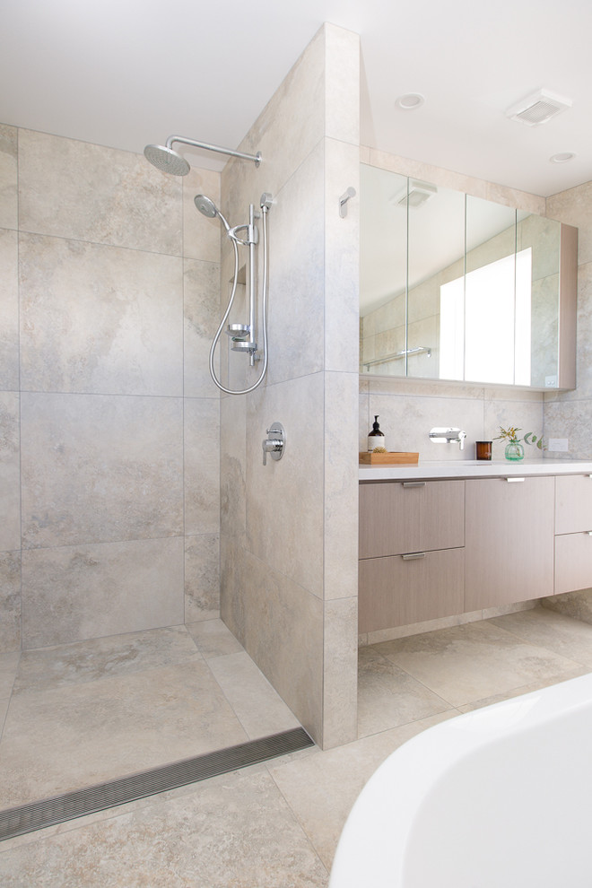 Small modern master bathroom in Other with furniture-like cabinets, light wood cabinets, a freestanding tub, an open shower, a one-piece toilet, white tile, ceramic tile, beige walls, ceramic floors, an undermount sink and engineered quartz benchtops.