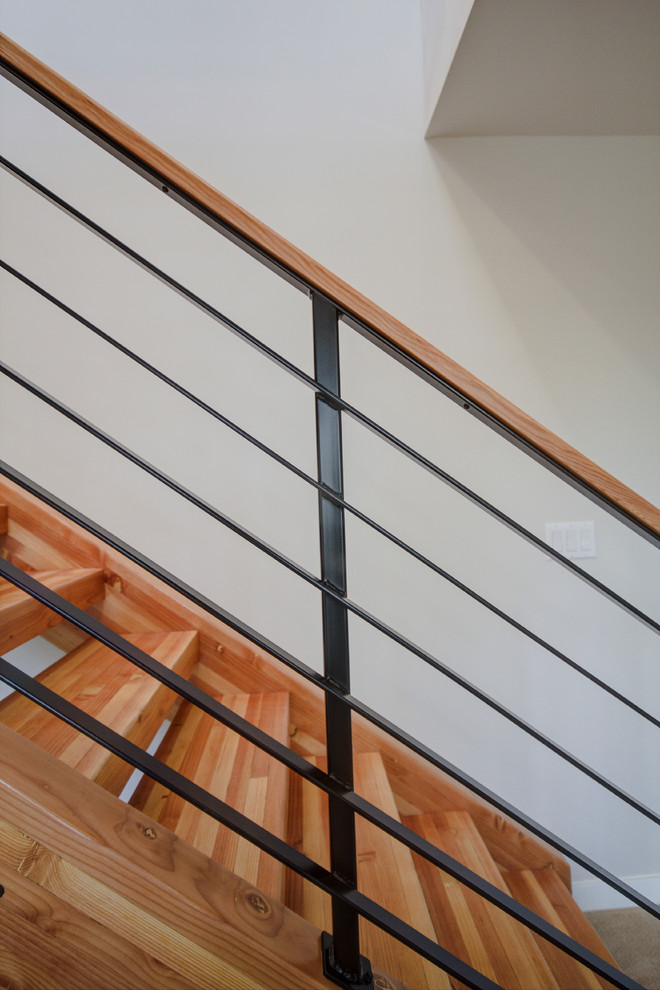 Photo of a mid-sized contemporary wood floating staircase in Seattle with wood risers and metal railing.