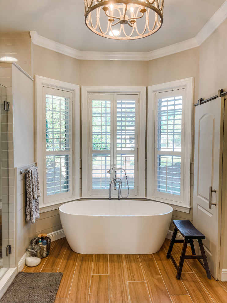 Klassisk inredning av ett stort en-suite badrum, med luckor med infälld panel, grå skåp, ett fristående badkar, en hörndusch, grå kakel, tunnelbanekakel, grå väggar och dusch med gångjärnsdörr