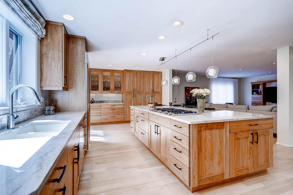 Design ideas for a large contemporary u-shaped open plan kitchen in Denver with an undermount sink, shaker cabinets, light wood cabinets, quartzite benchtops, stainless steel appliances, light hardwood floors and with island.