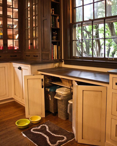 Kitchen cabinets with concealed pull-out bins storing bulk pet food under a window