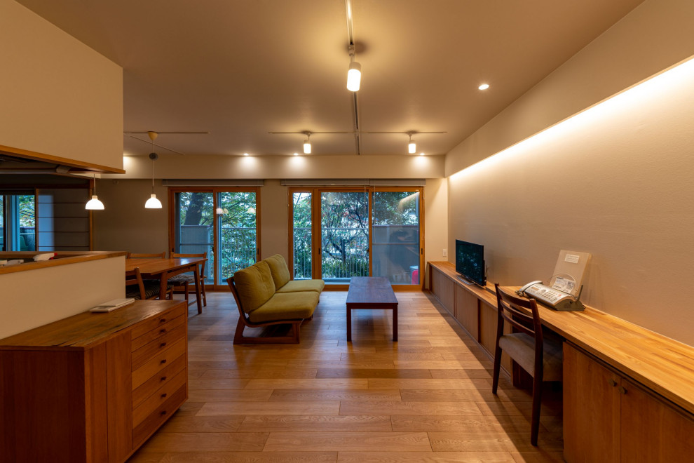 Mittelgroßes, Offenes Wohnzimmer mit weißer Wandfarbe, braunem Holzboden, freistehendem TV, braunem Boden, Tapetendecke und Tapetenwänden in Tokio