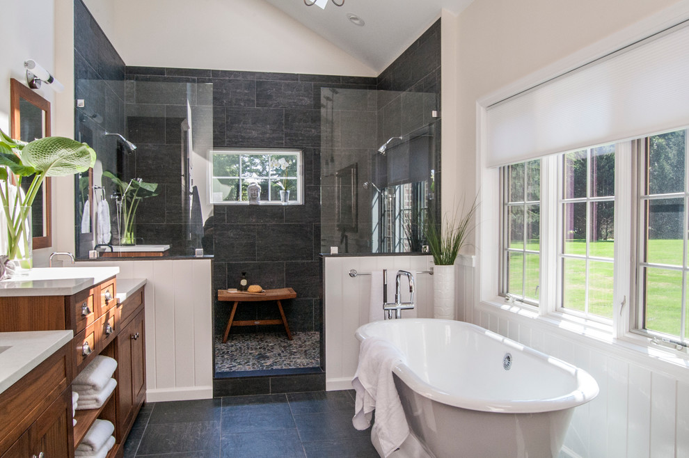 Large modern master bathroom in Philadelphia with an undermount sink, shaker cabinets, medium wood cabinets, engineered quartz benchtops, a freestanding tub, an open shower, a two-piece toilet, black tile, porcelain tile, beige walls and pebble tile floors.