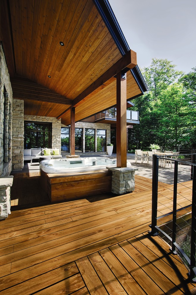 Trendy backyard deck photo with a roof extension