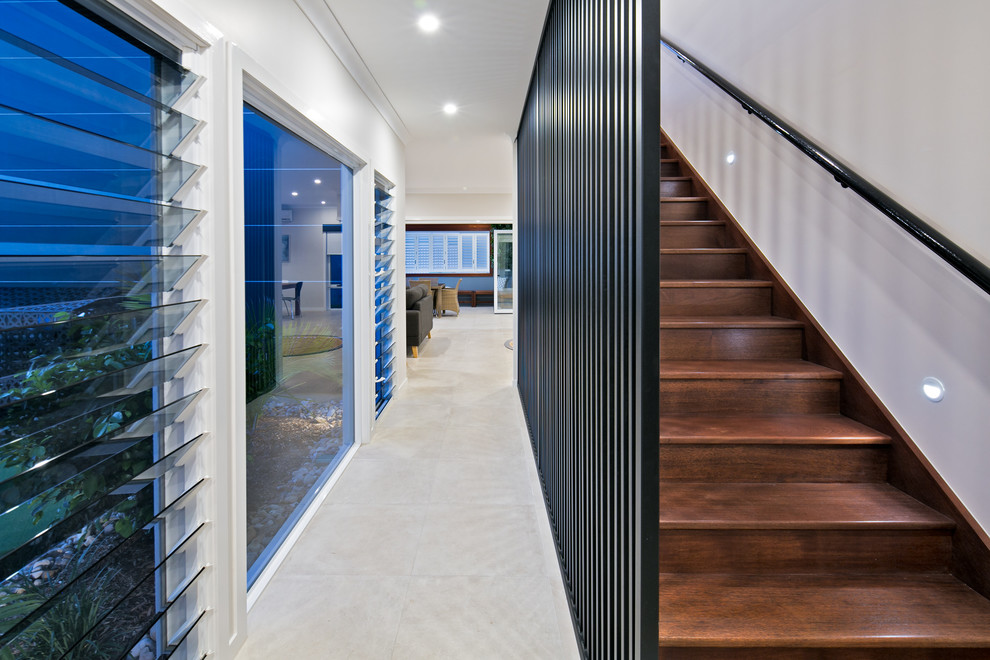 This is an example of a mid-sized contemporary wood straight staircase in Brisbane with wood risers and metal railing.