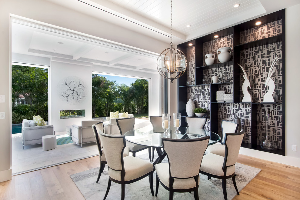 Contemporary dining room in Miami with white walls, light hardwood floors and brown floor.