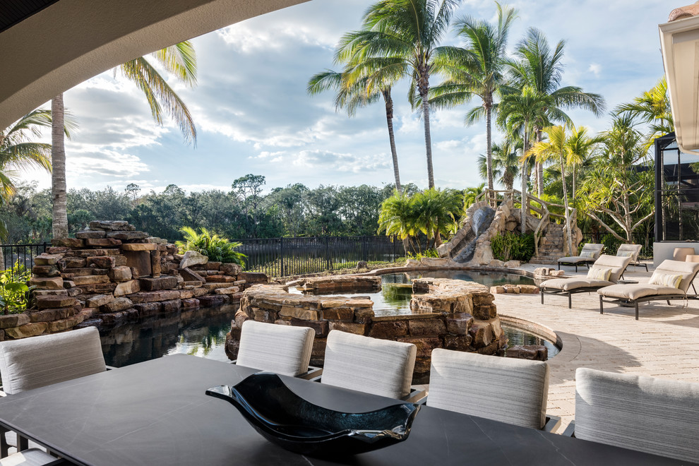 Tropical backyard patio in Miami with a water feature.