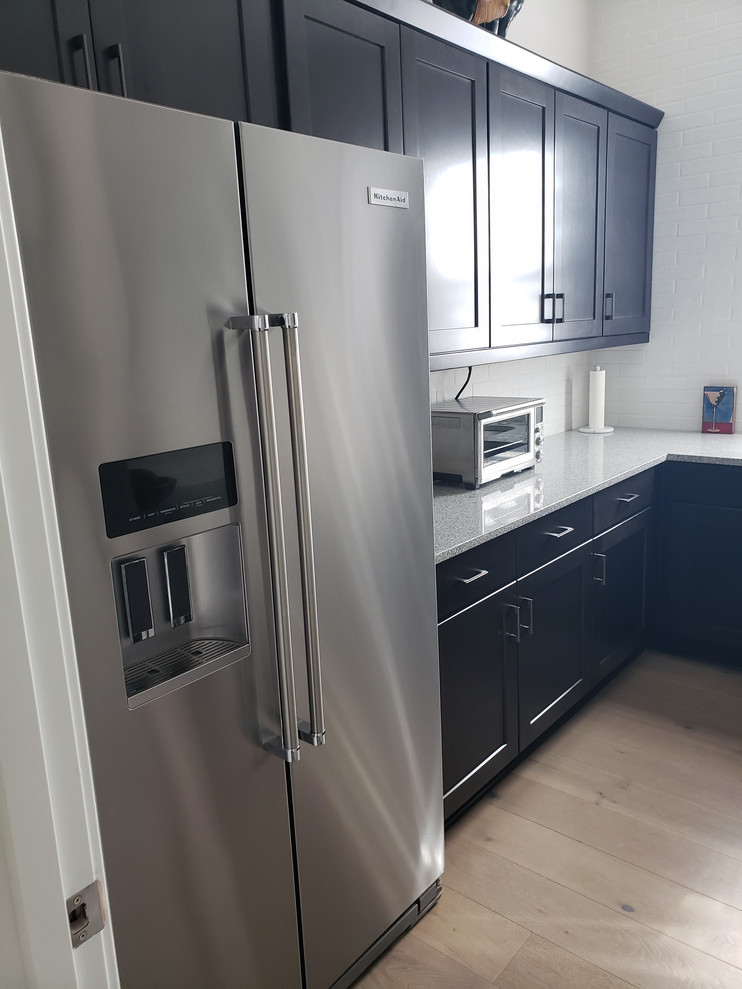 Inspiration for a large transitional kitchen pantry remodel in Phoenix with shaker cabinets, dark wood cabinets, quartz countertops, mosaic tile backsplash, stainless steel appliances, no island and white countertops