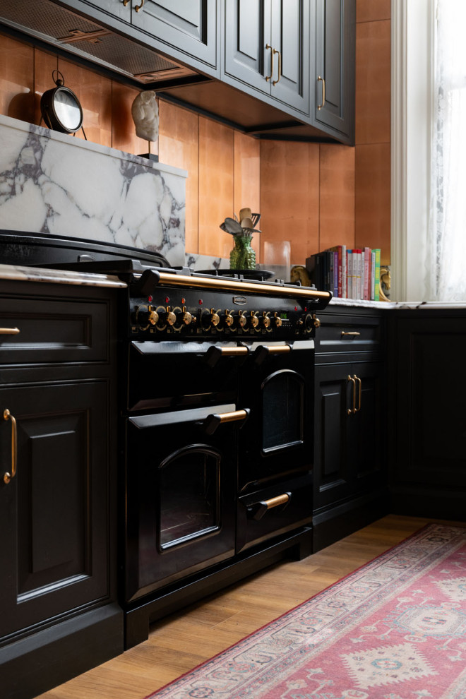 ロンドンにあるラグジュアリーな小さなヴィクトリアン調のおしゃれなキッチン (一体型シンク、レイズドパネル扉のキャビネット、黒いキャビネット、珪岩カウンター、白いキッチンパネル、クオーツストーンのキッチンパネル、黒い調理設備、無垢フローリング、茶色い床、白いキッチンカウンター) の写真