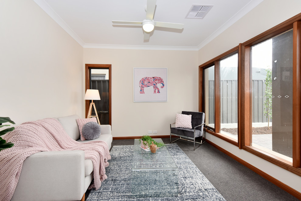 Photo of a contemporary enclosed family room in Adelaide with beige walls, carpet, no tv and grey floor.