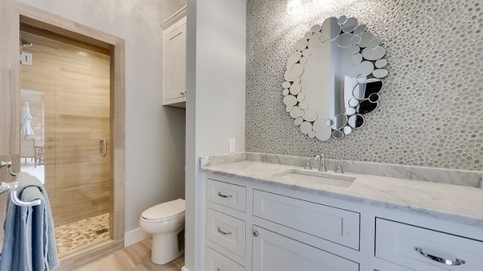 This is an example of a mid-sized contemporary 3/4 bathroom in Dallas with shaker cabinets, white cabinets, an alcove shower, a two-piece toilet, beige tile, brown tile, porcelain tile, grey walls, light hardwood floors, an undermount sink, marble benchtops, beige floor and a hinged shower door.