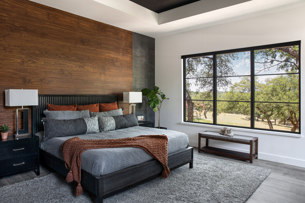 This is an example of a contemporary master bedroom in Austin with white walls, a standard fireplace and recessed.