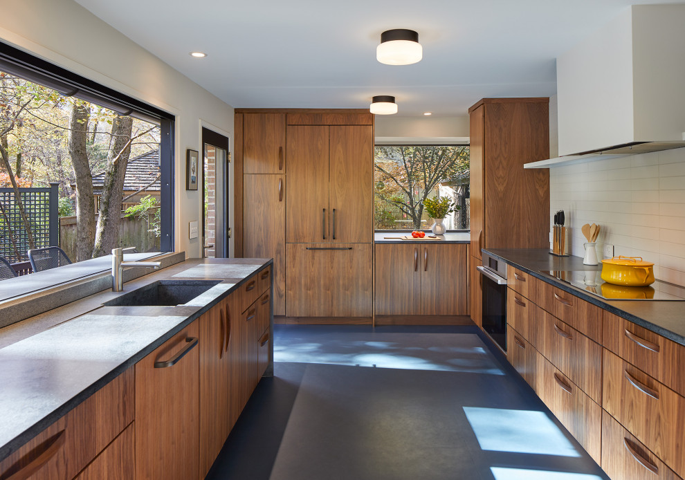 Inspiration for a midcentury kitchen in DC Metro with an integrated sink, flat-panel cabinets, medium wood cabinets, soapstone benchtops, white splashback, ceramic splashback, stainless steel appliances, linoleum floors, blue floor and grey benchtop.