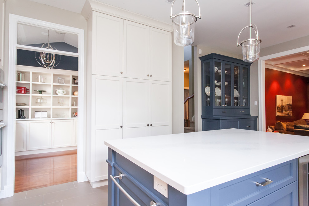 Example of a large transitional u-shaped porcelain tile and gray floor eat-in kitchen design in Toronto with an undermount sink, recessed-panel cabinets, white cabinets, quartz countertops, gray backsplash, subway tile backsplash, stainless steel appliances, an island and white countertops