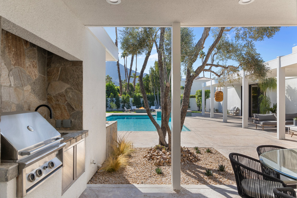 Large transitional backyard concrete patio kitchen photo with a roof extension