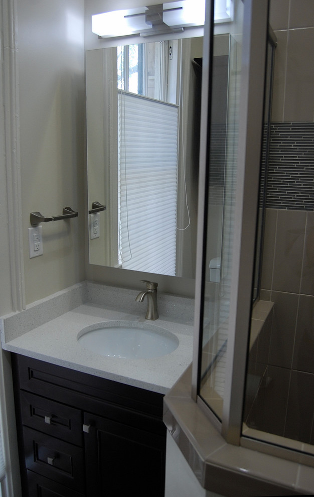 Photo of a small modern bathroom in Atlanta with an undermount sink, shaker cabinets, dark wood cabinets, quartzite benchtops, a corner shower, a one-piece toilet, beige tile, ceramic tile, beige walls and porcelain floors.