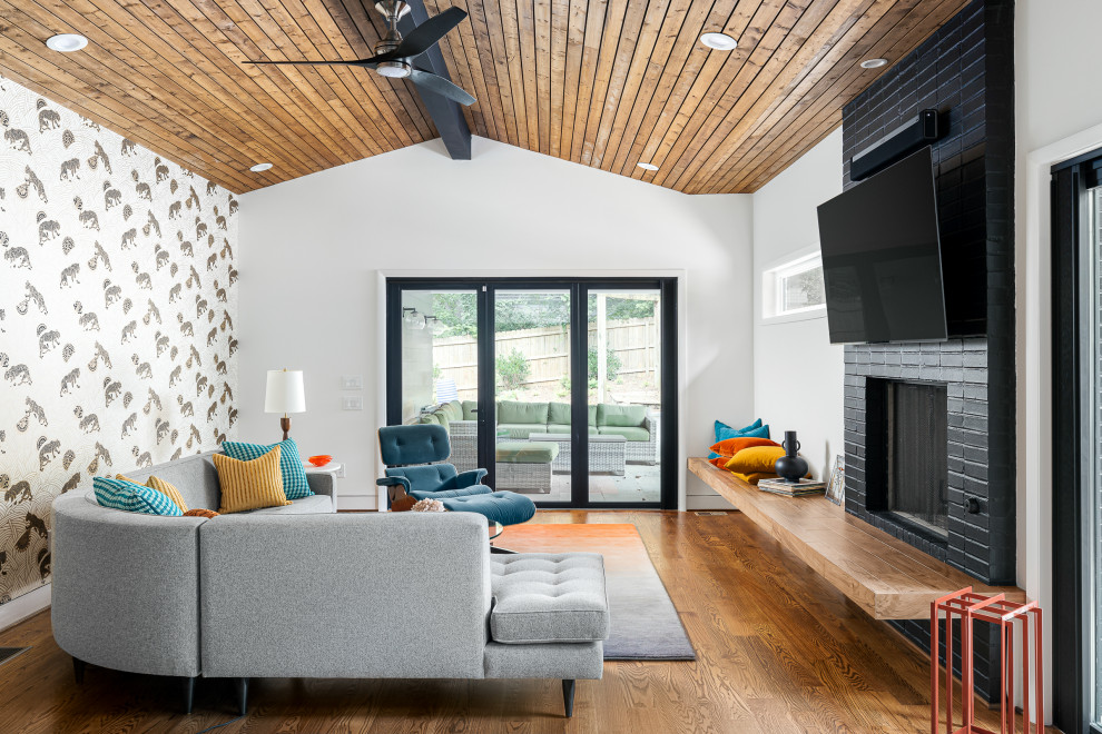 Foto de sala de estar abierta y abovedada contemporánea con paredes blancas, suelo de madera en tonos medios, todas las chimeneas, marco de chimenea de ladrillo y suelo marrón