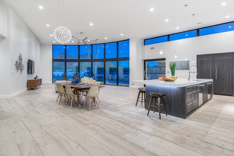This is an example of a large contemporary open concept living room in Phoenix with white walls, light hardwood floors, a wall-mounted tv and no fireplace.