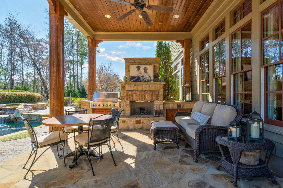 Inspiration for a medium sized classic back patio in Atlanta with a fireplace, natural stone paving and a roof extension.