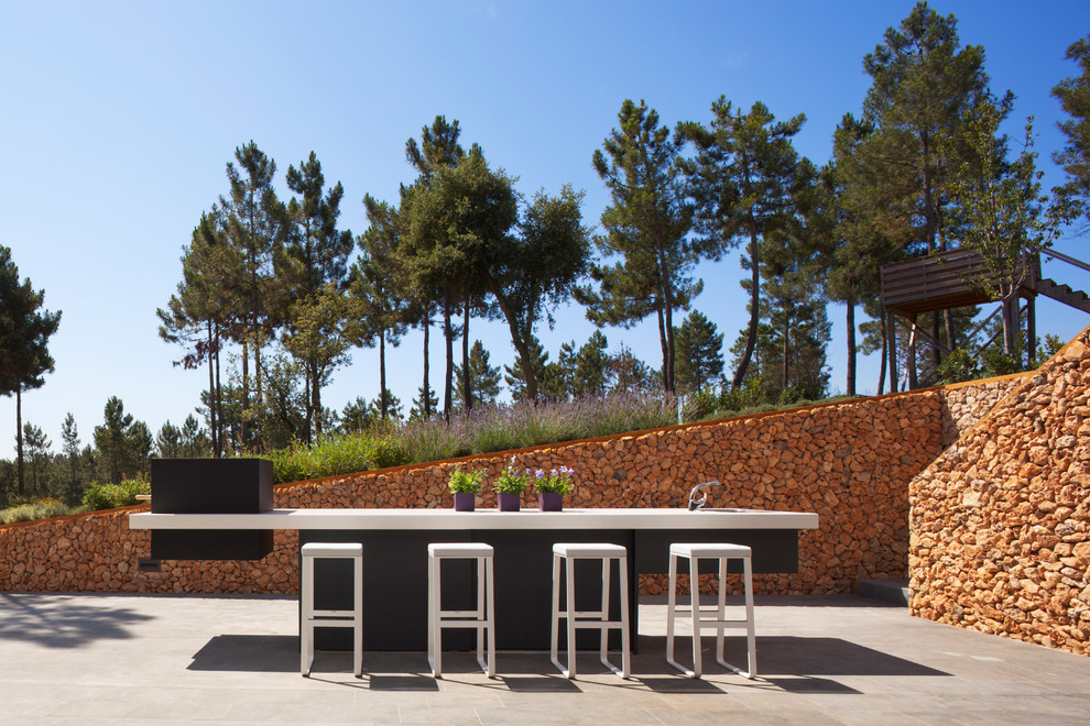 Large contemporary backyard patio in Barcelona with an outdoor kitchen, no cover and concrete slab.