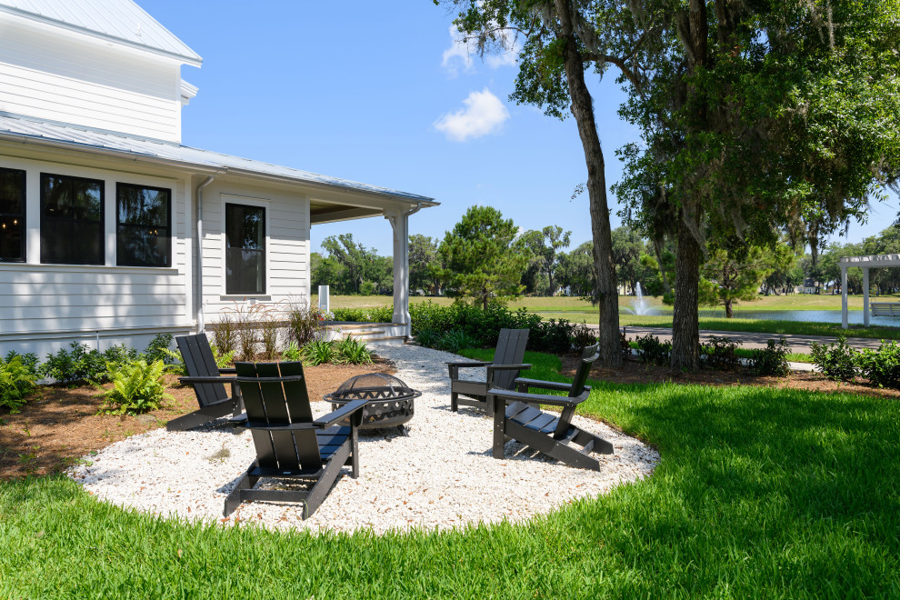 Inspiration for an expansive country side patio in Jacksonville with a fire feature, gravel and no cover.