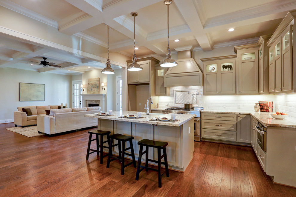 Inspiration for a large arts and crafts l-shaped separate kitchen in Houston with a farmhouse sink, shaker cabinets, grey cabinets, granite benchtops, white splashback, subway tile splashback, stainless steel appliances, medium hardwood floors and with island.