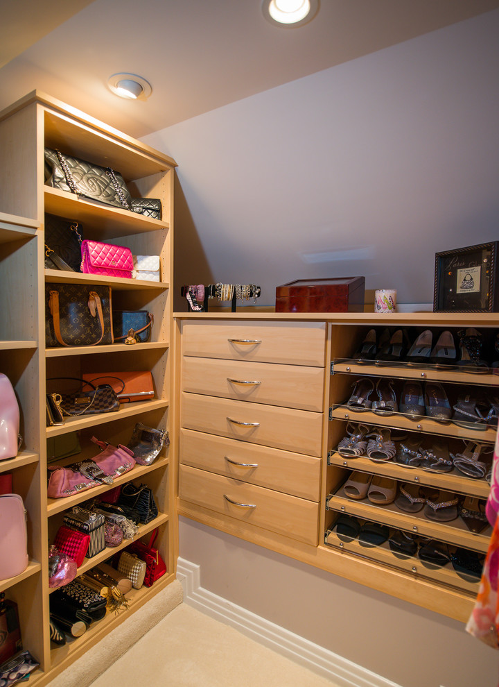 Large traditional women's dressing room in Richmond with glass-front cabinets, light wood cabinets and carpet.