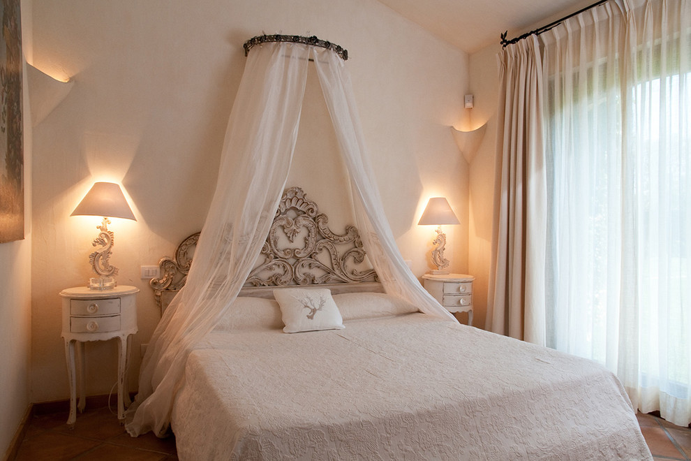 Photo of a small mediterranean guest bedroom in Other with pink walls, terra-cotta floors and red floor.