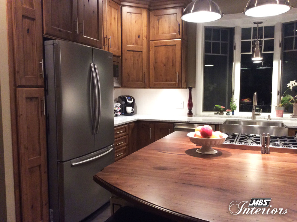 Eat-in kitchen - mid-sized transitional u-shaped ceramic tile and gray floor eat-in kitchen idea with a farmhouse sink, recessed-panel cabinets, medium tone wood cabinets, marble countertops, white backsplash, subway tile backsplash, stainless steel appliances and an island