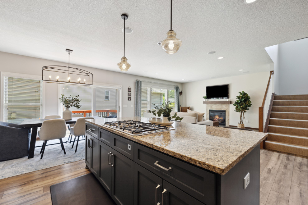 Eat-in kitchen - mid-sized transitional l-shaped vinyl floor and brown floor eat-in kitchen idea in Minneapolis with a double-bowl sink, shaker cabinets, white cabinets, granite countertops, white backsplash, ceramic backsplash, stainless steel appliances, an island and brown countertops