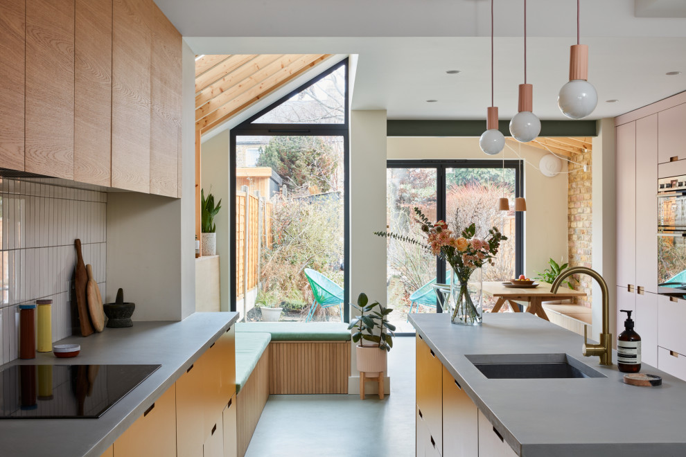 Inspiration for a contemporary kitchen in London with an undermount sink, flat-panel cabinets, pink cabinets, concrete benchtops, white splashback, ceramic splashback, linoleum floors, with island, green floor, grey benchtop and timber.