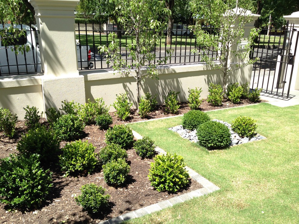 Mid-sized traditional front yard partial sun garden in Adelaide with a garden path and natural stone pavers.