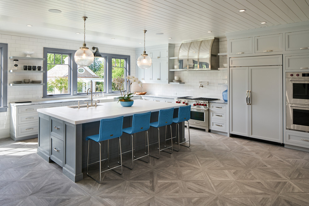 Inspiration for a large transitional l-shaped medium tone wood floor and gray floor eat-in kitchen remodel in New York with an undermount sink, recessed-panel cabinets, white cabinets, quartzite countertops, white backsplash, subway tile backsplash, paneled appliances and an island