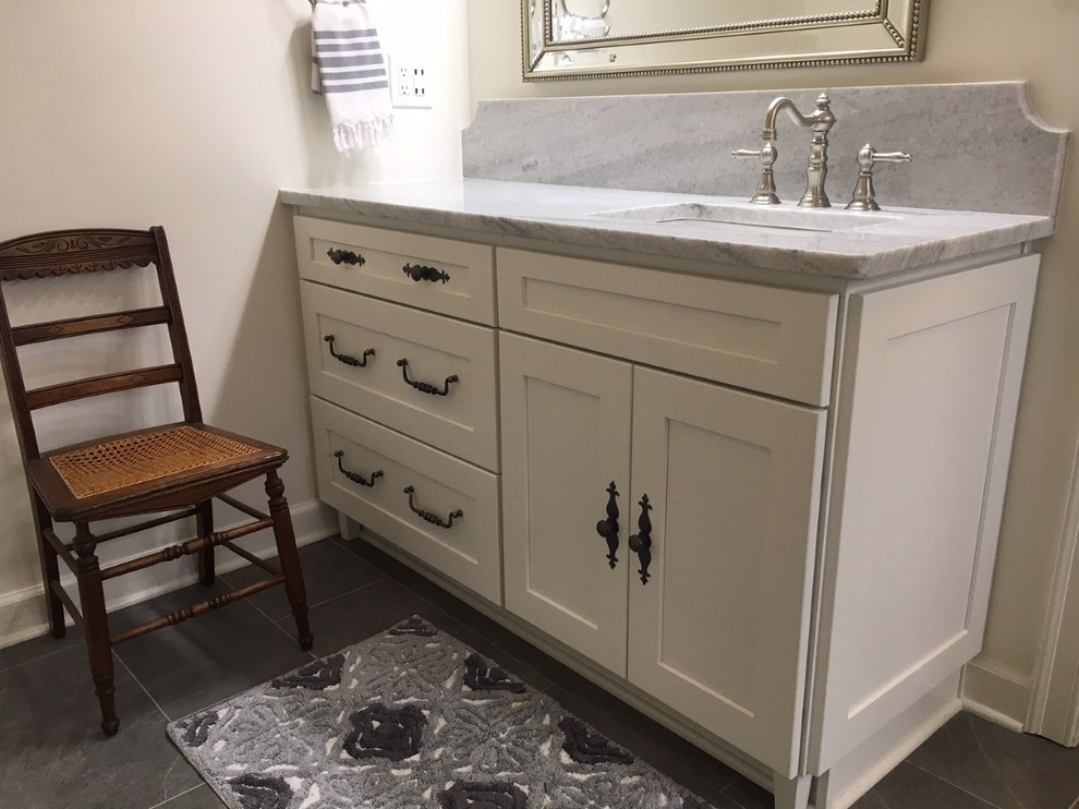 Example of a mid-sized transitional master white tile and ceramic tile porcelain tile and gray floor corner shower design with recessed-panel cabinets, white cabinets, an undermount tub, a two-piece toilet, gray walls, an undermount sink, marble countertops and a hinged shower door
