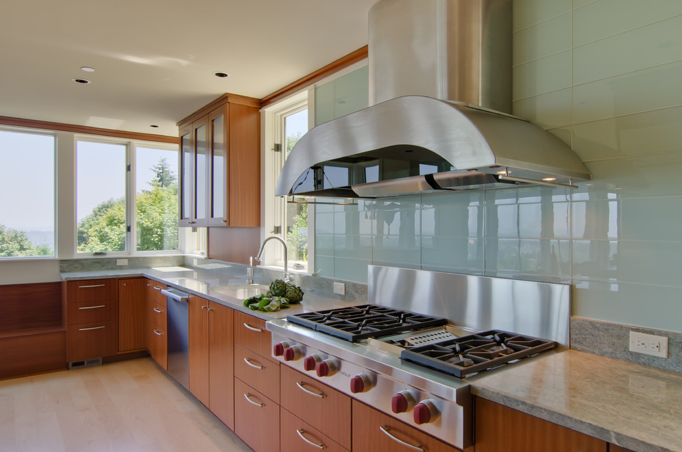 Inspiration for a mid-sized modern l-shaped separate kitchen in Portland with an undermount sink, flat-panel cabinets, light wood cabinets, quartz benchtops, green splashback, glass sheet splashback, stainless steel appliances, light hardwood floors, with island and beige floor.