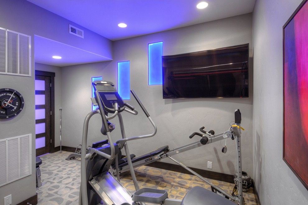 This is an example of a small contemporary home weight room in Other with grey walls and carpet.