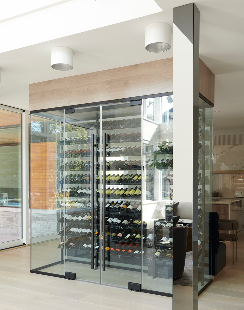 Expansive contemporary wine cellar in Toronto with light hardwood flooring and beige floors.