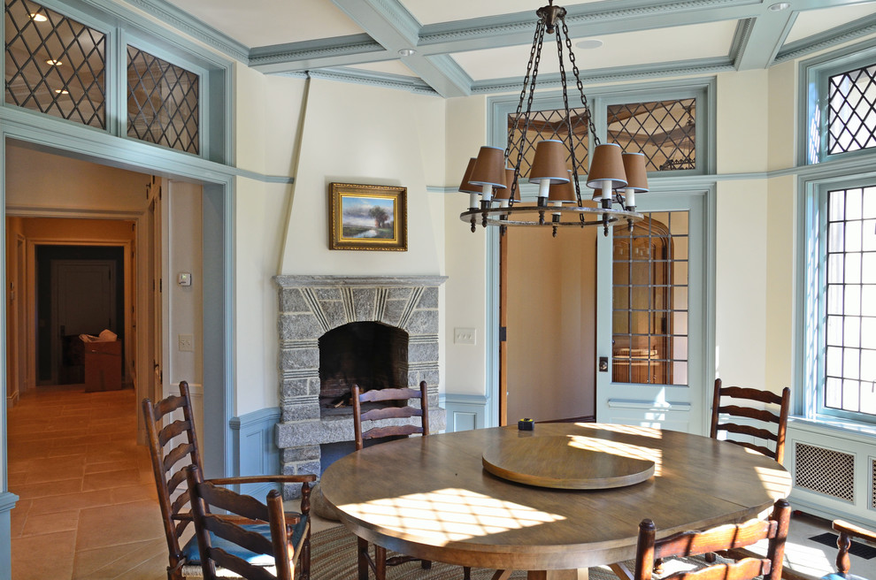 This is an example of a traditional separate dining room in Other with a standard fireplace, beige walls, a stone fireplace surround and beige floor.