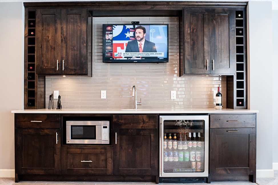 Photo of a mid-sized traditional single-wall wet bar in Minneapolis with an undermount sink, shaker cabinets, dark wood cabinets, quartzite benchtops, grey splashback, subway tile splashback and vinyl floors.