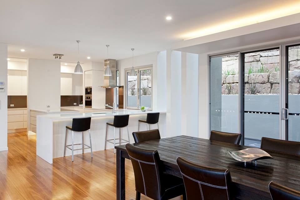 Large modern open plan dining in Brisbane with white walls and light hardwood floors.