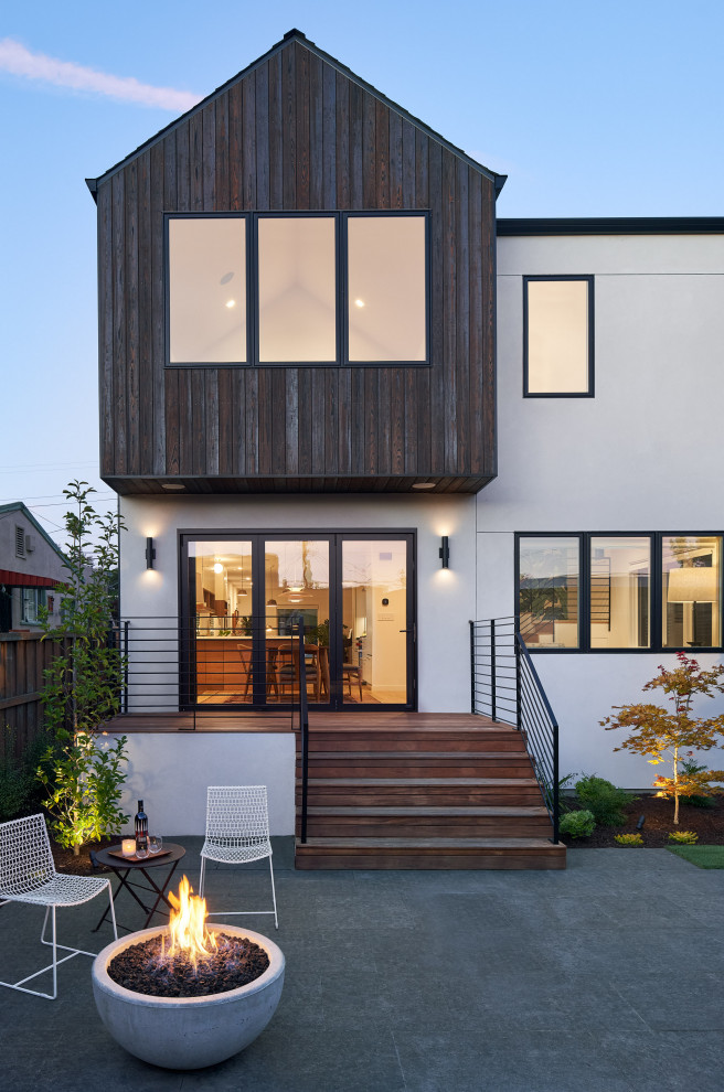 Design ideas for a white midcentury two floor render house exterior in San Francisco with a black roof.