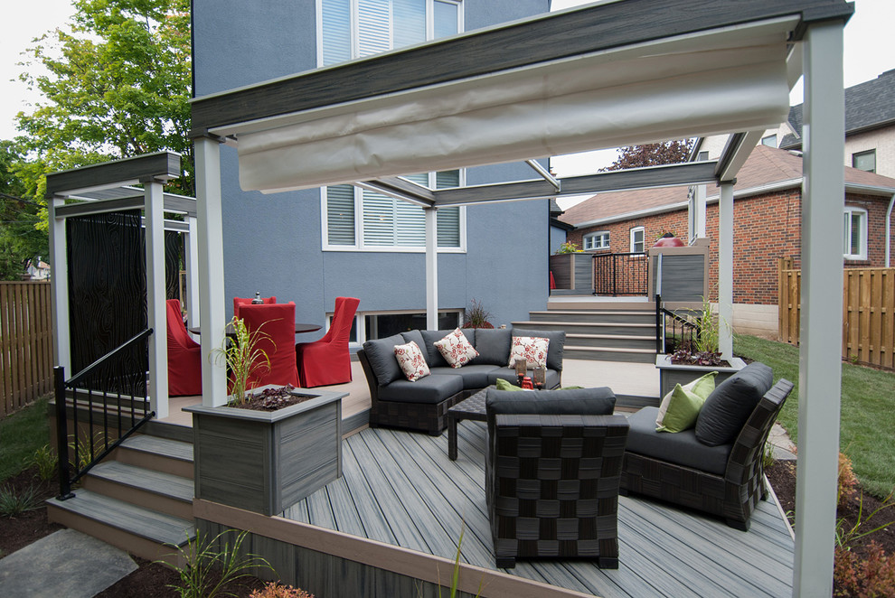 Inspiration for a mid-sized contemporary backyard deck in Toronto with an outdoor kitchen and an awning.